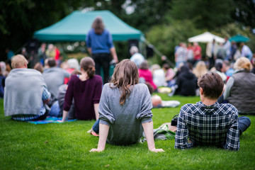 Outdoor event with people sitting on the ground